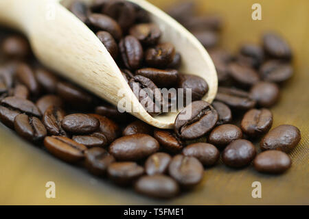 Dettaglio di caffè torrefatto in grani sul convogliatore di legno Foto Stock