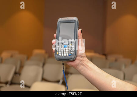 Donna che mantiene Portable Barcode Scanner dispositivo lettore Foto Stock