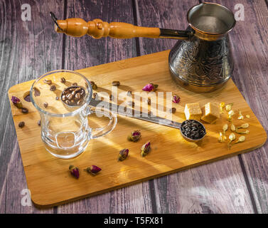 Misurino per il tè e il caffè con i chicchi di caffè e asciugare le foglie di tè wth vetro tazza di tè e rame cezve arancione con manico in legno per il caffè turco Foto Stock