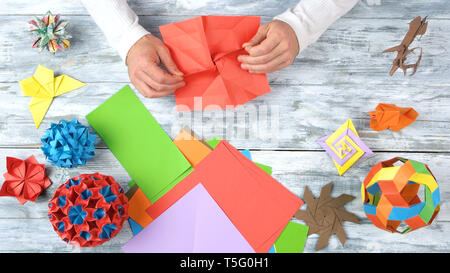 Progetti di origami sul bianco sullo sfondo di legno. Foto Stock