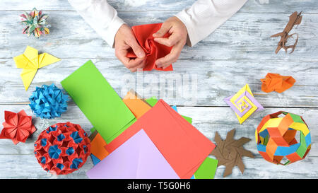 Progetti di origami sul bianco sullo sfondo di legno. Foto Stock