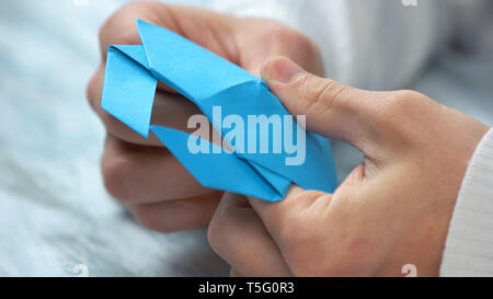 Close up mani maschio folding origami figura. Foto Stock