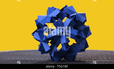 Origami blu sfera floreali su sfondo giallo. Foto Stock