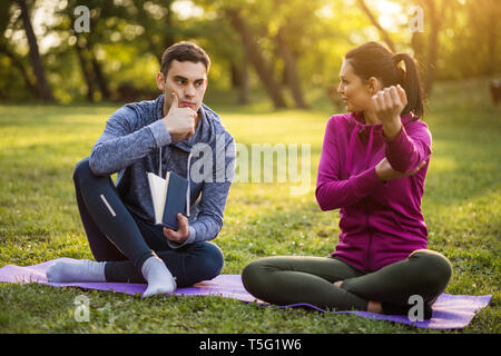 Fisioterapista e il paziente sta parlando di lesioni fisiche. Foto Stock