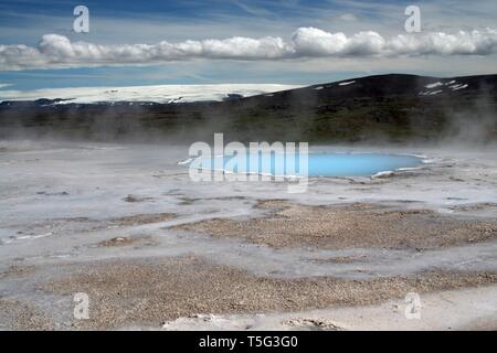 Seltun / Krysuvik (Krýsuvík): fumante valle geotermale con naturale blu piscina e nevato mountain Foto Stock