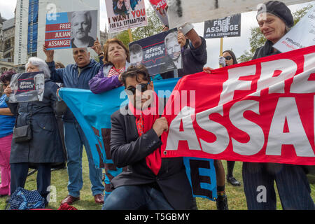 Londra, Regno Unito. 24 apr, 2019. Afshin Rattansi da RT "Going Underground" pone il programma con i manifestanti in piazza del Parlamento per chiedere la liberazione di Julian Assange. Si dice che egli non dovrebbe essere estradati negli Stati Uniti come una volta lì sarà caricato con più gravi crimini e rinchiuso per tutta la vita come un deterrente per altri informatori. Altoparlanti inclusi i diritti umani Attivista Peter Tatchell e Afshin Rattansi da RT "Going Underground' news programma. Credito: Peter Marshall / Alamy Live News Foto Stock