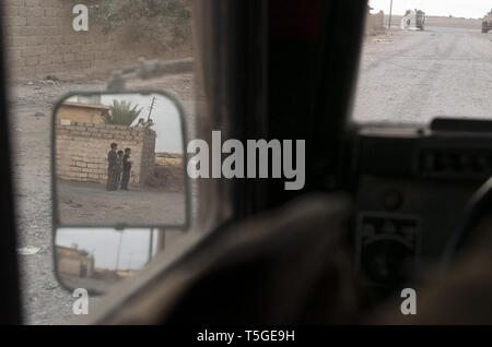 Bayji, Salah ad Din, Iraq. 12 dic 2005. I bambini guardano al passaggio di un esercito americano pattuglia in Bayji, Iraq, Dicembre 12, 2005. Credito: Bill Putnam/ZUMA filo/Alamy Live News Foto Stock