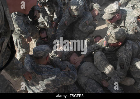 Bayji, Salah ad Din, Iraq. 3 Dic 2005. Fanti in 1Lt. Andrea Jensen il plotone di Abu Company, 1° Battaglione, 187th Reggimento di Fanteria dargli una pancia rosa nella celebrazione della sua promozione a livello FOB Summerall, Iraq, Dicembre 3, 2005. Credito: Bill Putnam/ZUMA filo/Alamy Live News Foto Stock