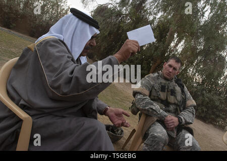 Bayji, Salah ad Din, Iraq. 12 dic 2005. Un shiek tribali parla di Capt. Adam lacchè, comandante di Abu Company, 1° Battaglione, 187th Reggimento di Fanteria, nella sua casa di Bayji, Iraq, Dicembre 12, 2005. Credito: Bill Putnam/ZUMA filo/Alamy Live News Foto Stock