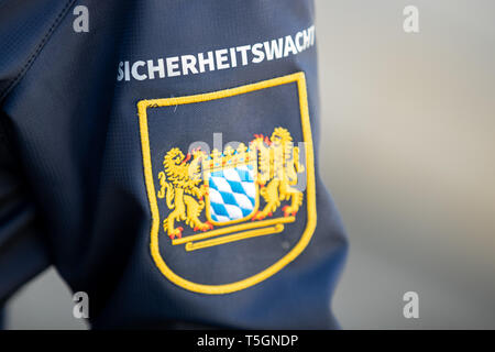 Norimberga, Germania. Xxv Aprile, 2019. Il lettering della bavarese la guardia di sicurezza si erge sopra la bavarese stemma su un nuovo pezzo di abbigliamento. I volontari ricevono il neon giallo di avvertimento canottiere, torce elettriche e un migliorato spruzzo di pepe per la XXV anniversario. Il nuovo blu scuro abbigliamento di la guardia di sicurezza è modellato sulla corrente di polizia bavarese uniformi. Credito: Daniel Karmann/dpa/Alamy Live News Foto Stock