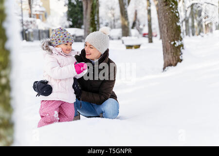 Felice madre con la figlia nel paesaggio invernale Foto Stock
