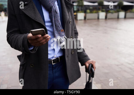 La mano di imprenditore tenendo il telefono cellulare Foto Stock