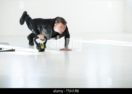 L uomo che sta facendo il suo regime fitness, bollitore facendo bell push-up Foto Stock