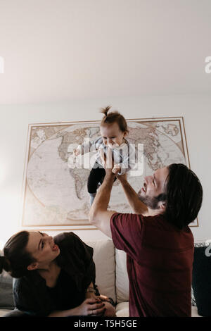 La famiglia felice giocando con baby girl nel salotto di casa Foto Stock