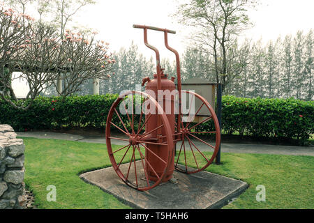 Vintage red estintore, ntique rosso fuoco extinguishe sul giardino verde ad alta risoluzione galleria dell'immagine. Foto Stock