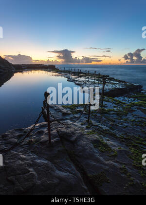 Alba attraverso il Bogey Hole - Newcastle NSW Australia. Questo convict scavato ocean pool risale al 1819 ed è uno dei Newcastles più famosa terra Foto Stock