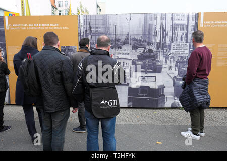 Berlino, Germania - turisti e visitatori di guardare una guerra fredda era la foto del Checkpoint Charlie border crossing in corrispondenza della stessa posizione di oggi Foto Stock