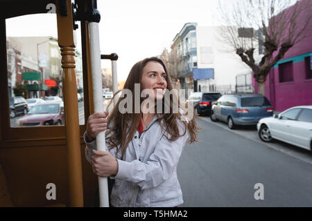 Donna felice appeso al di fuori del veicolo in movimento Foto Stock