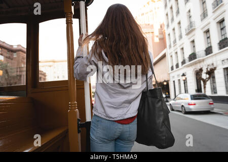 Donna felice appeso al di fuori del veicolo in movimento Foto Stock