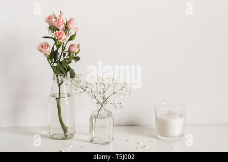 Elegante composizione minimalista con rose e gypsophila fiori sulla parete tabella di sfondo. Vista frontale mockup. Foto Stock
