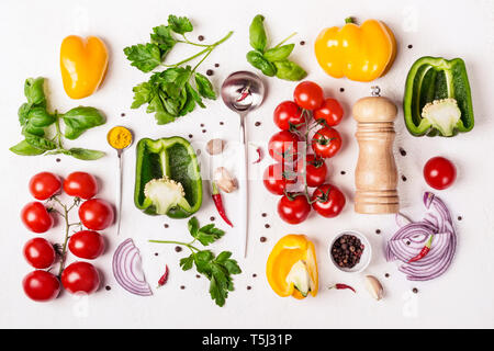 Varietà di verdure fresche, macinaspezie e cucchiaio con olio di oliva. Sfondo di cibo e il concetto di cucina a vista. Foto Stock