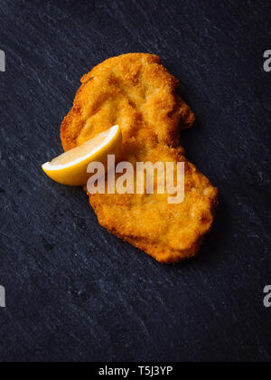 Wiener Schnitzel e la fetta di limone su ardesia Foto Stock