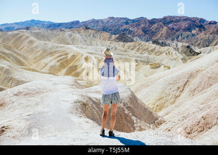 Stati Uniti, California, Parco Nazionale della Valle della Morte, venti Team Mule Canyon, vista posteriore madre bambino portando la ragazza Foto Stock