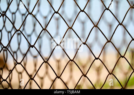 Filo di acciaio recinzione per evitare pericolose aree lungo la spiaggia e la sfocatura sullo sfondo Foto Stock