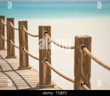 Posti di legno e corda ringhiere sul molo su mare tropicale con Laguna Foto Stock