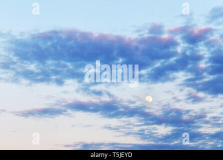 Skyline serale con le nuvole colorate e luna Foto Stock