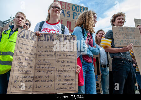 Una studentessa olandese è visto ascoltare discorsi tenendo un enorme cartellone durante la protesta. Ispirato dalla scuola mondiale colpisce per il clima, centinaia di persone si sono radunate in Piazza Dam a continuare la lotta per un cambiamento nelle politiche sul clima e di un futuro migliore. Questo sciopero che è stato organizzato da diverse organizzazioni, è stato anche il più grande sciopero degli studenti nei Paesi Bassi. Foto Stock