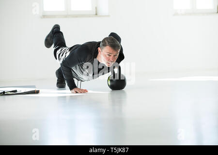 L uomo che sta facendo il suo regime fitness, bollitore facendo bell push-up Foto Stock