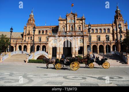 Vista dell'edificio centrale nella Plaza de Espana con carrozze trainate da cavalli in primo piano, Siviglia, Siviglia, Spagna Foto Stock