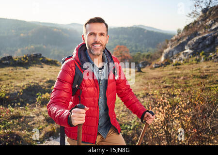 Ritratto di uomo sorridente su una escursione in montagna Foto Stock
