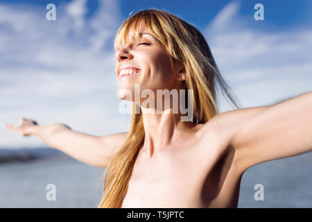 Ritratto di felice giovane donna godendo la luce solare Foto Stock