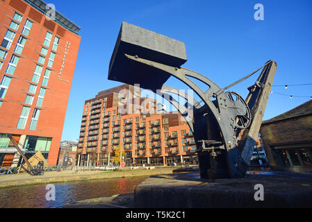 Fiume aire e la vecchia gru sulla banchina da negozi e uffici al clarence dock leeds Yorkshire Regno Unito Foto Stock