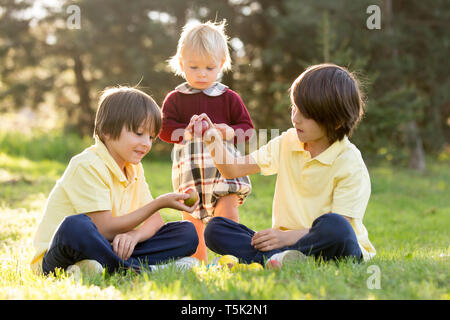 Dolce bambini, ragazzo fratelli con orecchie di coniglietto, caccia all'uovo di Pasqua, il bambino e il giorno di Pasqua tradizioni. I ragazzi e le vacanze Foto Stock