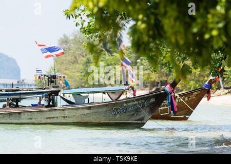 KRABI, Thailandia - Marzo 2019: di legno lunga coda imbarcazioni con bandiere Thai oscillazione in mare nei pressi di Railey Beach Foto Stock