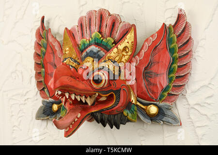 Rosso demone Balinese Danza Barong maschera da Garuda Indonesia su una parete in stucco Foto Stock