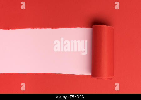 Rosso carta torned su sfondo rosa Foto Stock