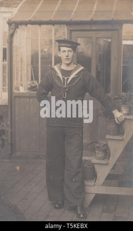 Vintage Cartolina fotografica che mostra una British Royal Navy Sailor da H.M.S.Queen Mary Foto Stock