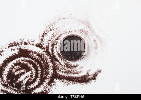 Scrub corpo di macinato di caffè e lo zucchero nel recipiente su tavolo bianco, piatto laici composizione minima. Foto Stock