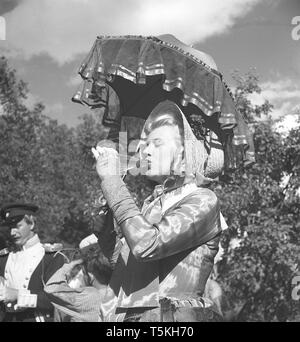 1940s'attrice. Una giovane donna sul set di un film vestito in abiti storici è il raffreddamento da bere da una bottiglia. Foto Kristoffersson ref V48-6. La Svezia 1947 Foto Stock