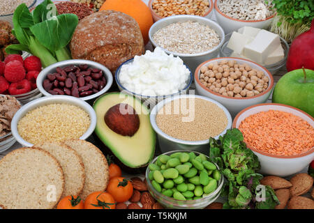 Della salute alimentare per i vegani con mandorla yogurt, tofu tofu, legumi, cereali, verdure, frutta, cereali, noci, semi, cereali integrali pane e crackers. Foto Stock