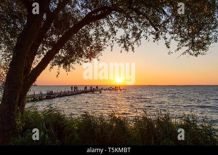 I turisti a guardare il tramonto dal Molo al Lago Steinhude / Steinhuder Meer in estate, Mardorf, Bassa Sassonia / Bassa Sassonia, Germania Foto Stock