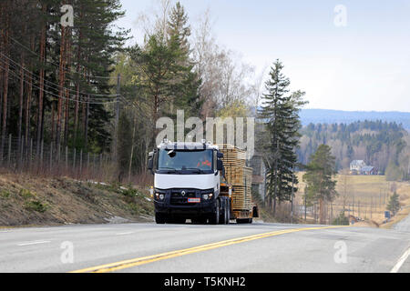 Salo, Finlandia - 19 Aprile 2019: Bianco Renault Trucks semi traina un carico di larghezza di legname sul rimorchio con collo d'oca lungo la panoramica strada statale in un giorno di primavera. Foto Stock