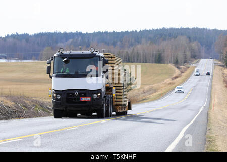 Salo, Finlandia - 19 Aprile 2019: Bianco Renault Trucks semi traina un carico di larghezza di legname sul rimorchio con collo d'oca lungo l autostrada in un giorno di primavera. Foto Stock