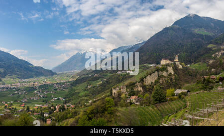 Vista panoramica su Castel Tirolo con castello Castel Fontana all'interno della valle e sulle Alpi di Merano. Tirol Village, Provincia di Bolzano, Alto Adige, Italia. Foto Stock