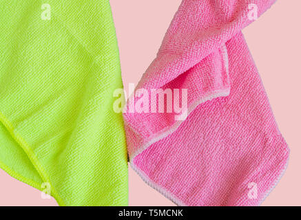 Panni in microfibra isolato su sfondo rosa, strumenti per la pulizia e la pulizia. Il concetto di pulizia di primavera, piatto laici. Foto Stock