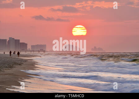 Luminosa alba, con le nuvole, lungo la spiaggia oltre oceano Atlantico con onde che si infrangono lungo il litorale, in Gulf Shores, Orange Beach, Alabama, STATI UNITI D'AMERICA Foto Stock